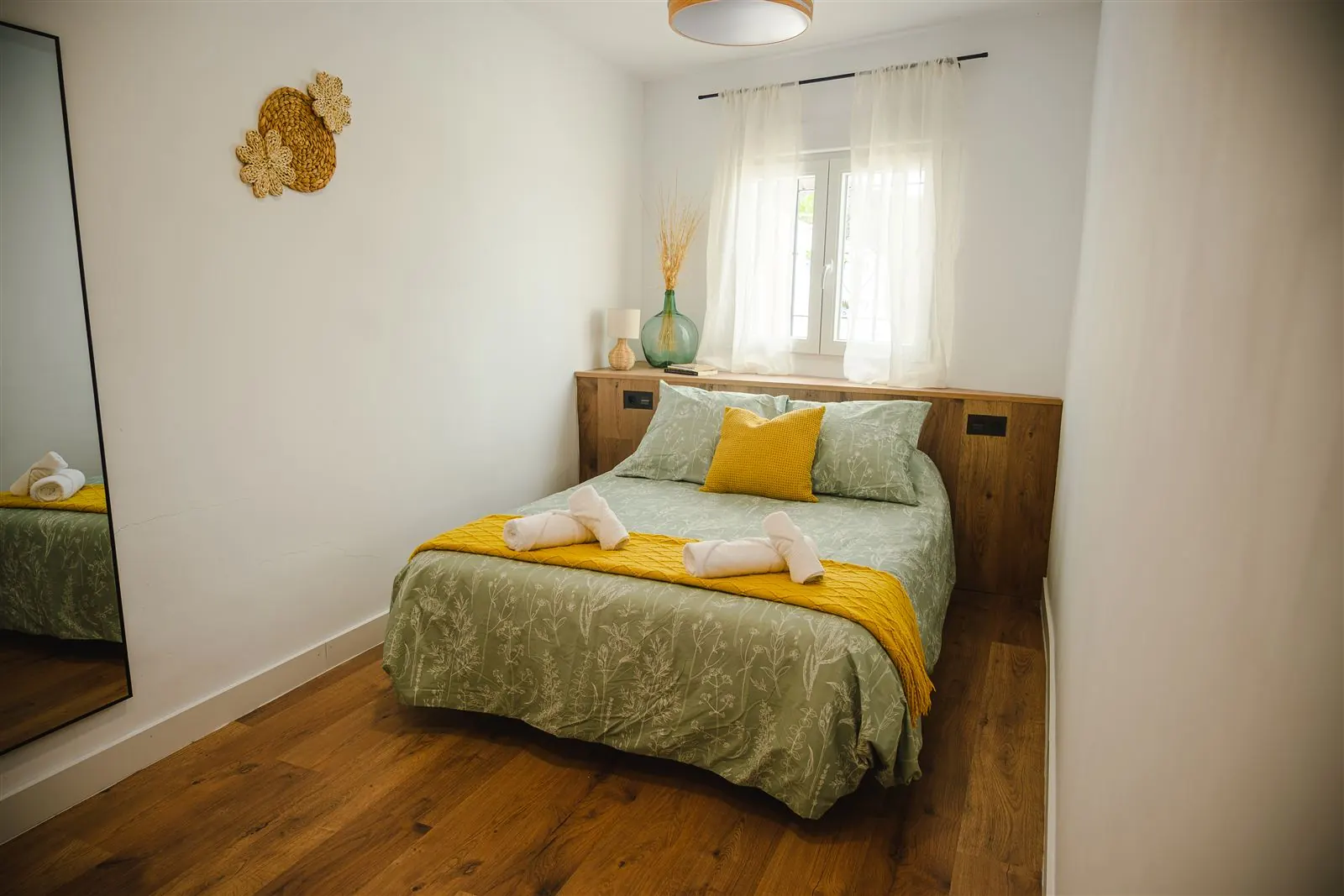 Segunda habitación con cama doble y detalles en mostaza
